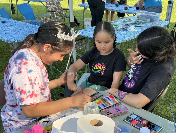 kids having their arms painted at the farmers market