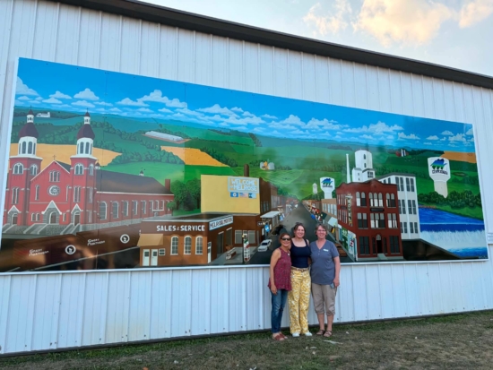 artist and project leaders in front of the new mural