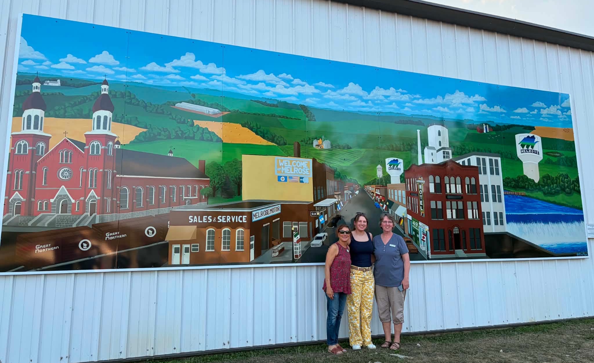 artist and project leaders in front of the new mural